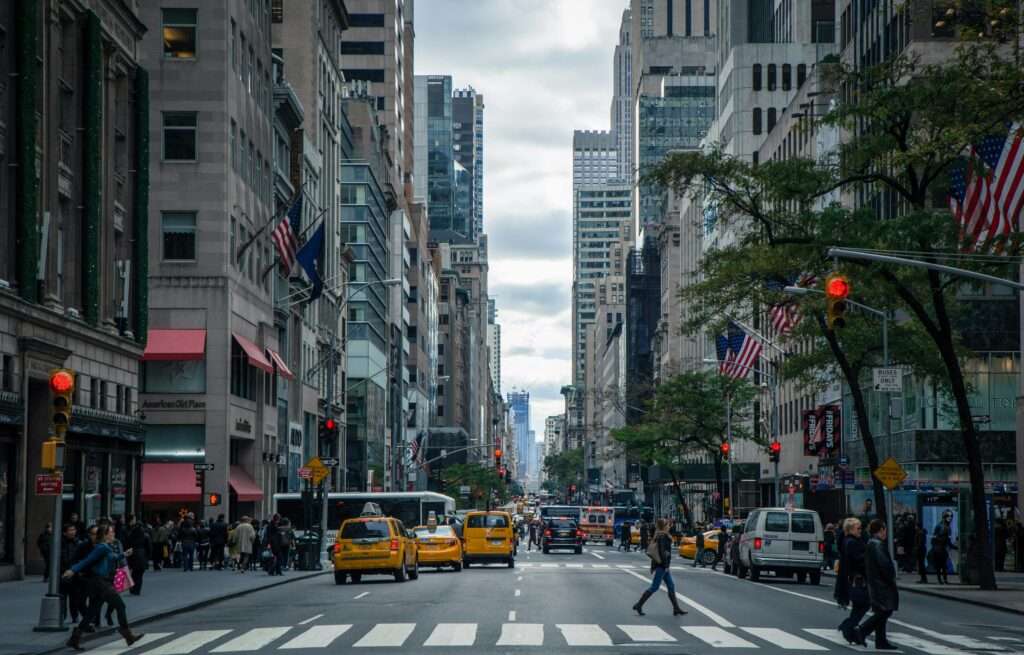 A New York City street with people, cars and buildings.