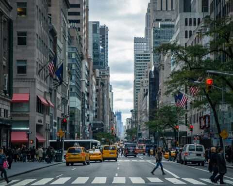 A New York City street with people, cars and buildings.