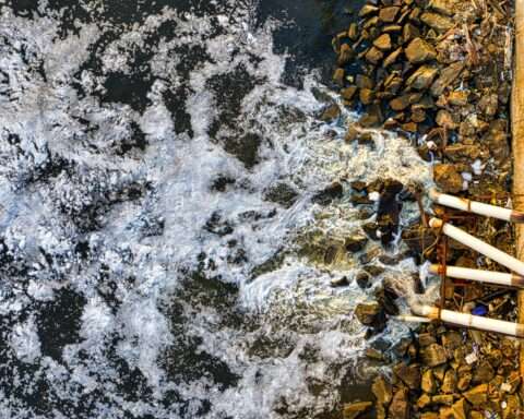 An aerial view of wastewater being poured into a body of water.