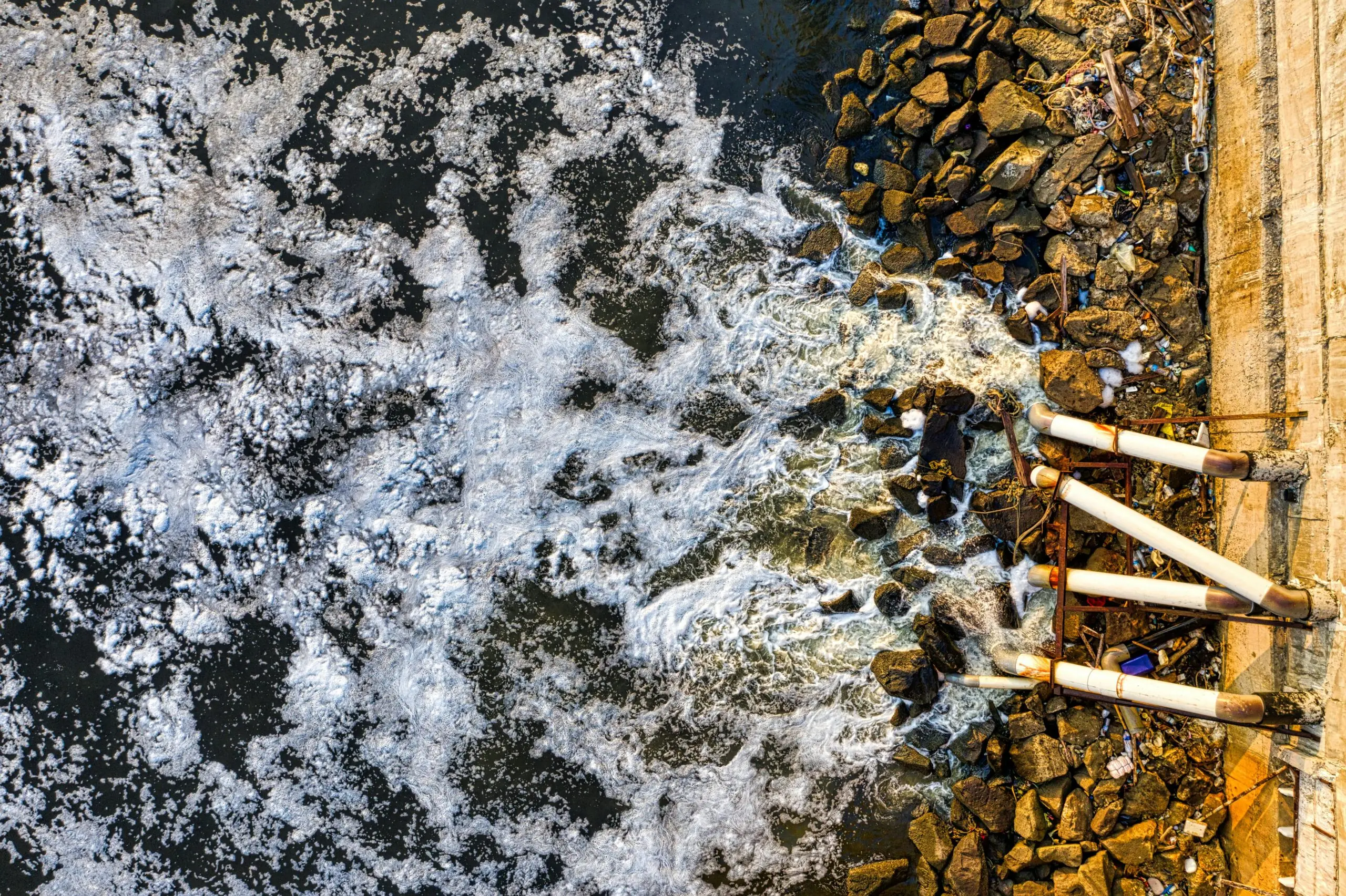 An aerial view of wastewater being poured into a body of water.