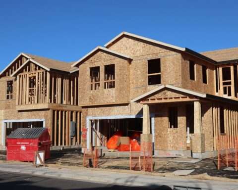 A housing development on a construction site before a cloudy grey sky.