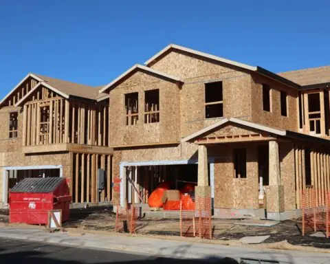 A housing development on a construction site before a cloudy grey sky.