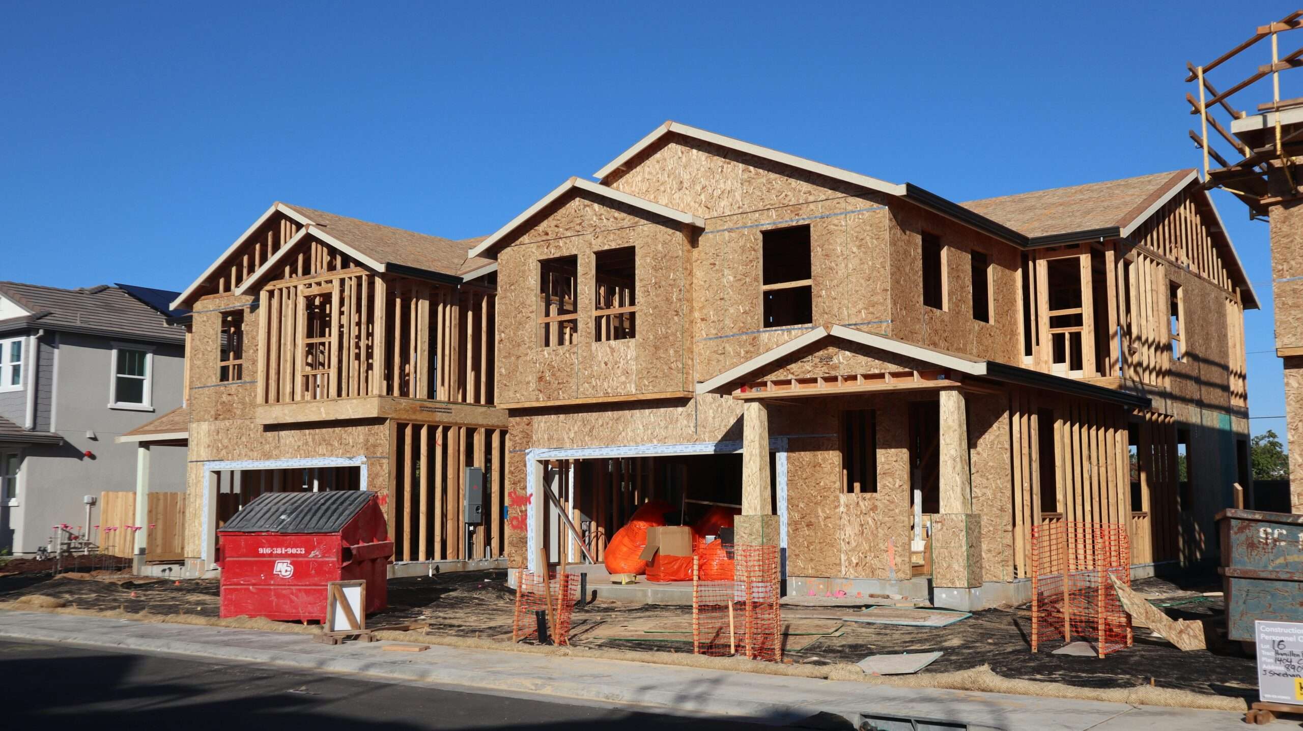 A housing development on a construction site before a cloudy grey sky.