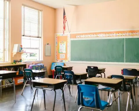 A school classroom with chairs and a chalkboard.