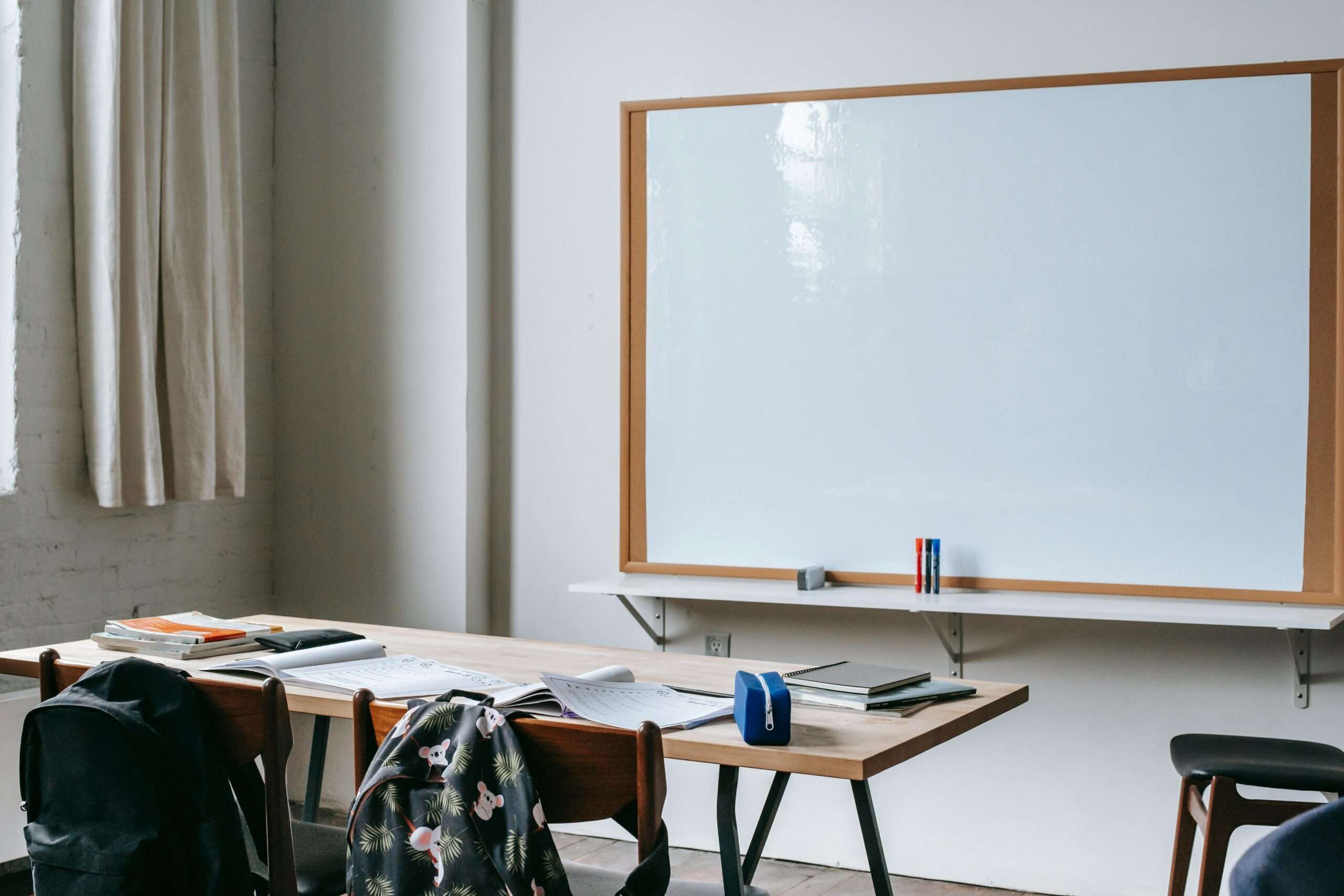 A whiteboard behind a desk in a classroom.
