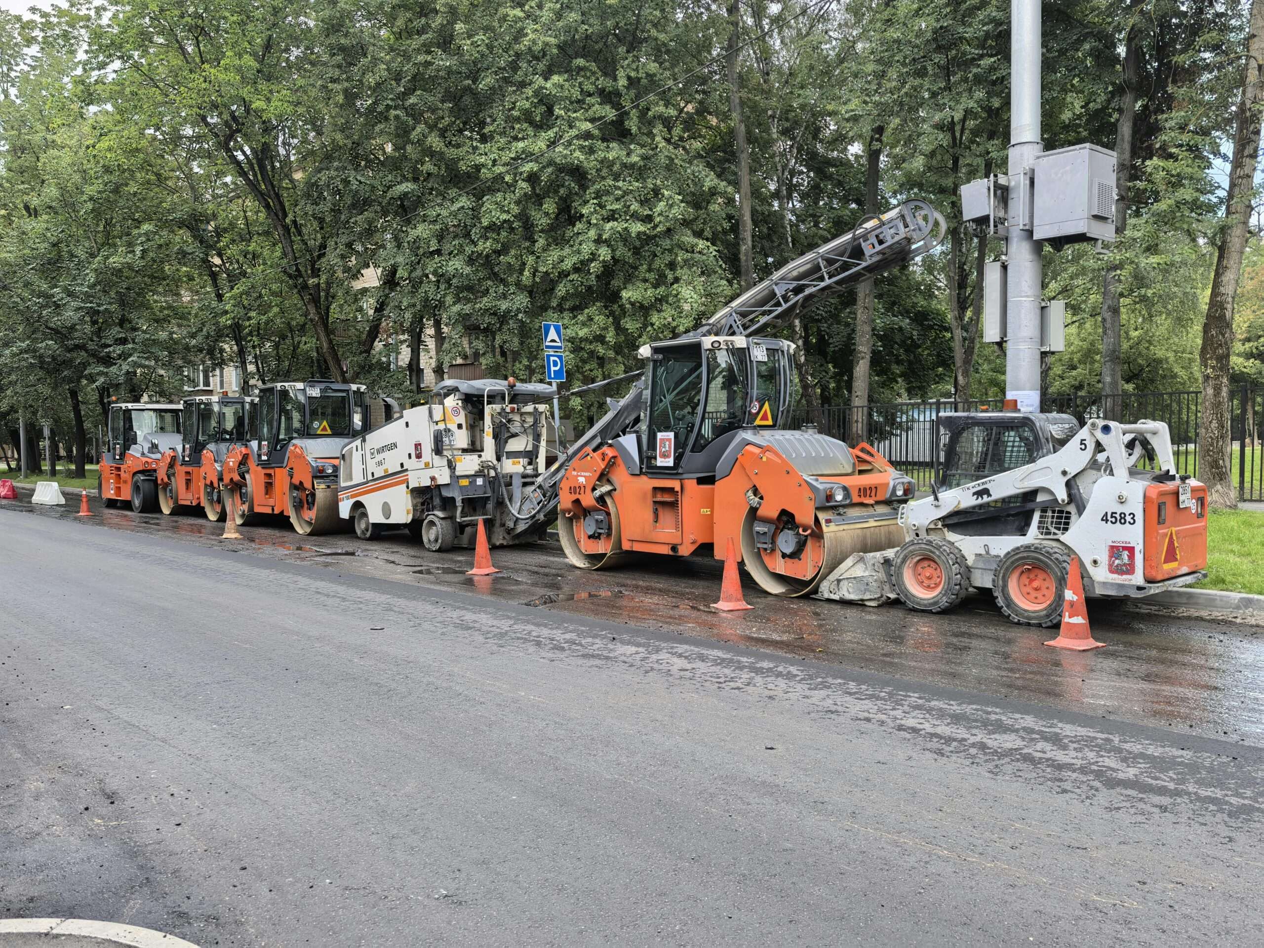 Work vehicles sit alongside a boulevard to prepare for construction.