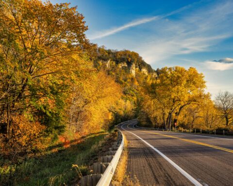 A roadway in Wisconsin nearby Autumn trees.