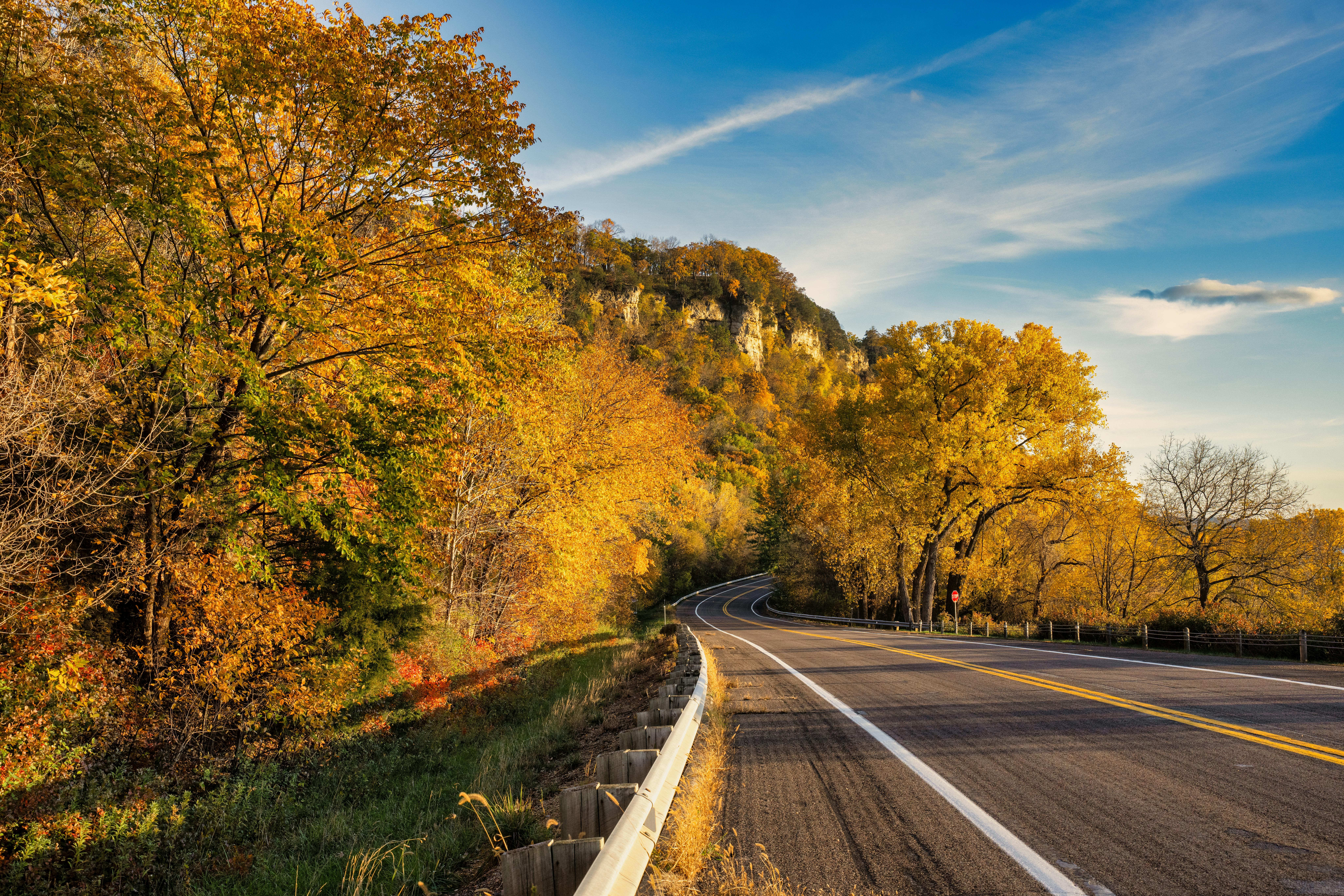 A roadway in Wisconsin nearby Autumn trees.