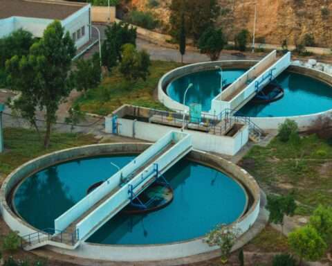 An aerial view of a water treatment facility with two tanks full of water.