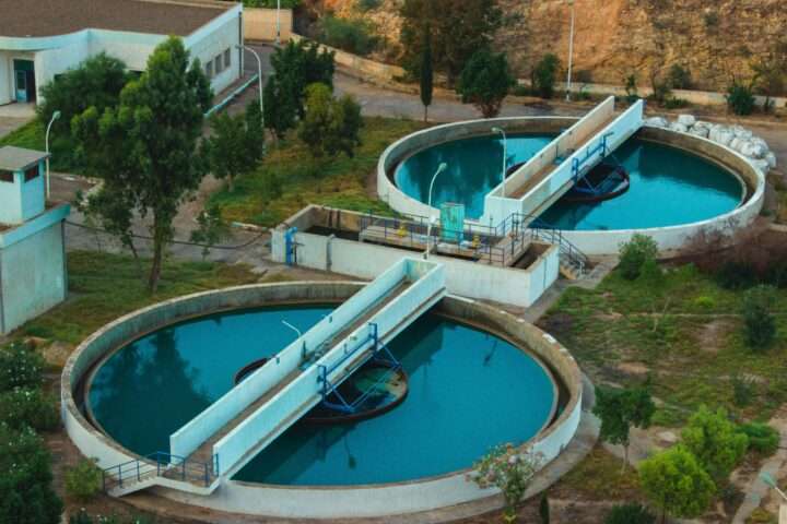 An aerial view of a water treatment facility with two tanks full of water.