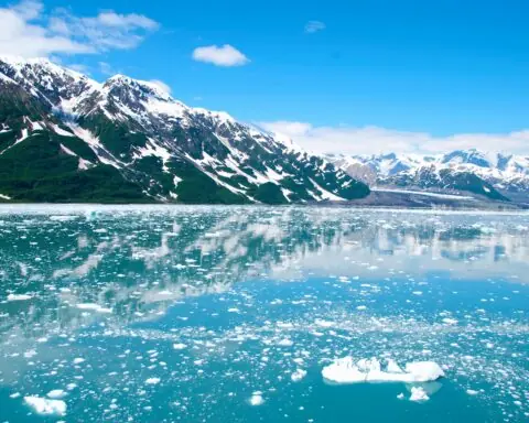 A frozen lake in Alaska before snowcapped mountains.