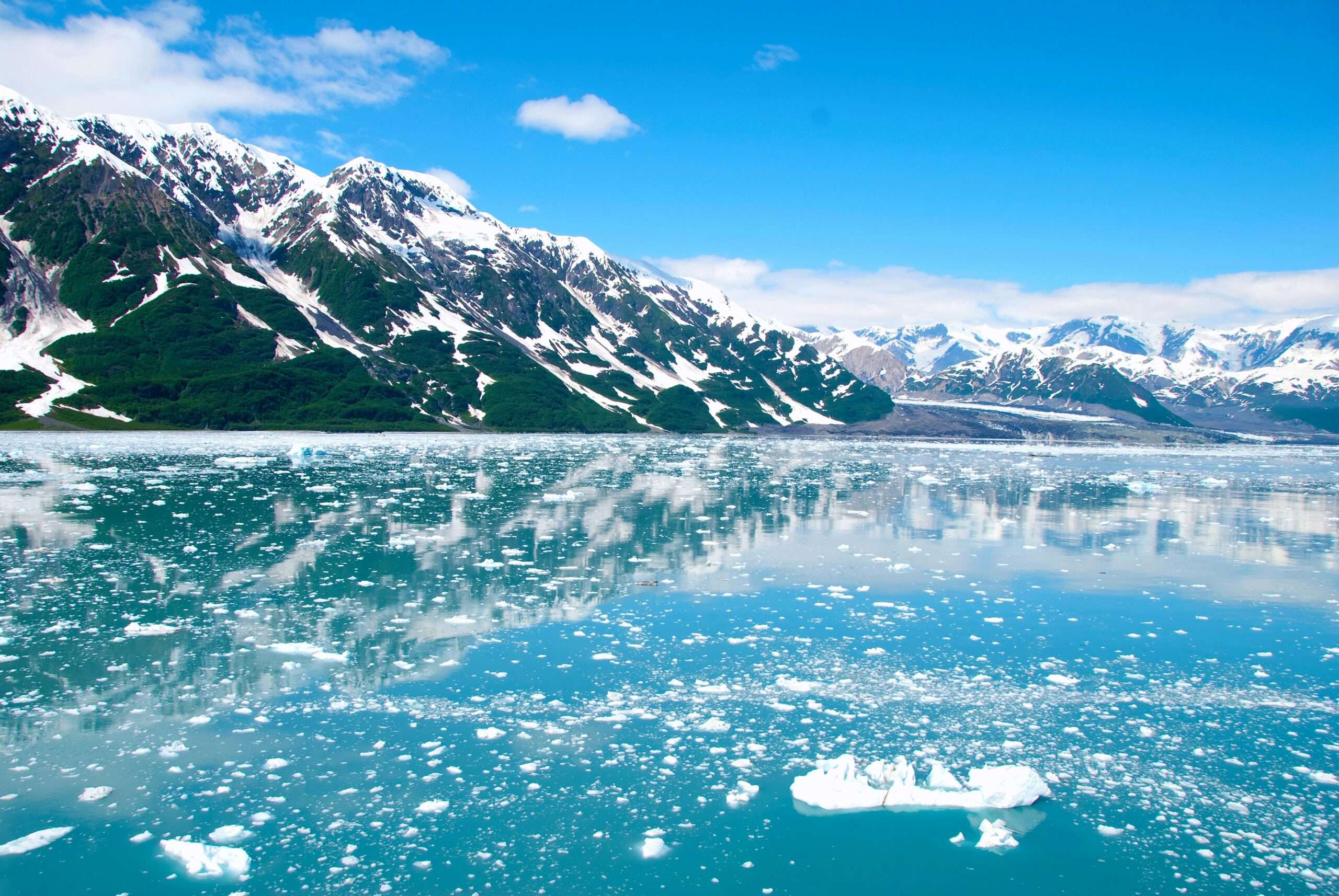 A frozen lake in Alaska before snowcapped mountains.