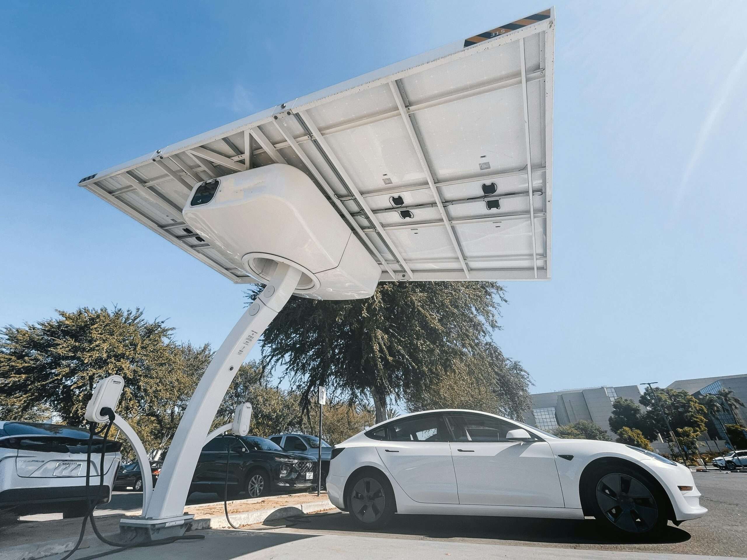 An EV charging station with a white car parked.