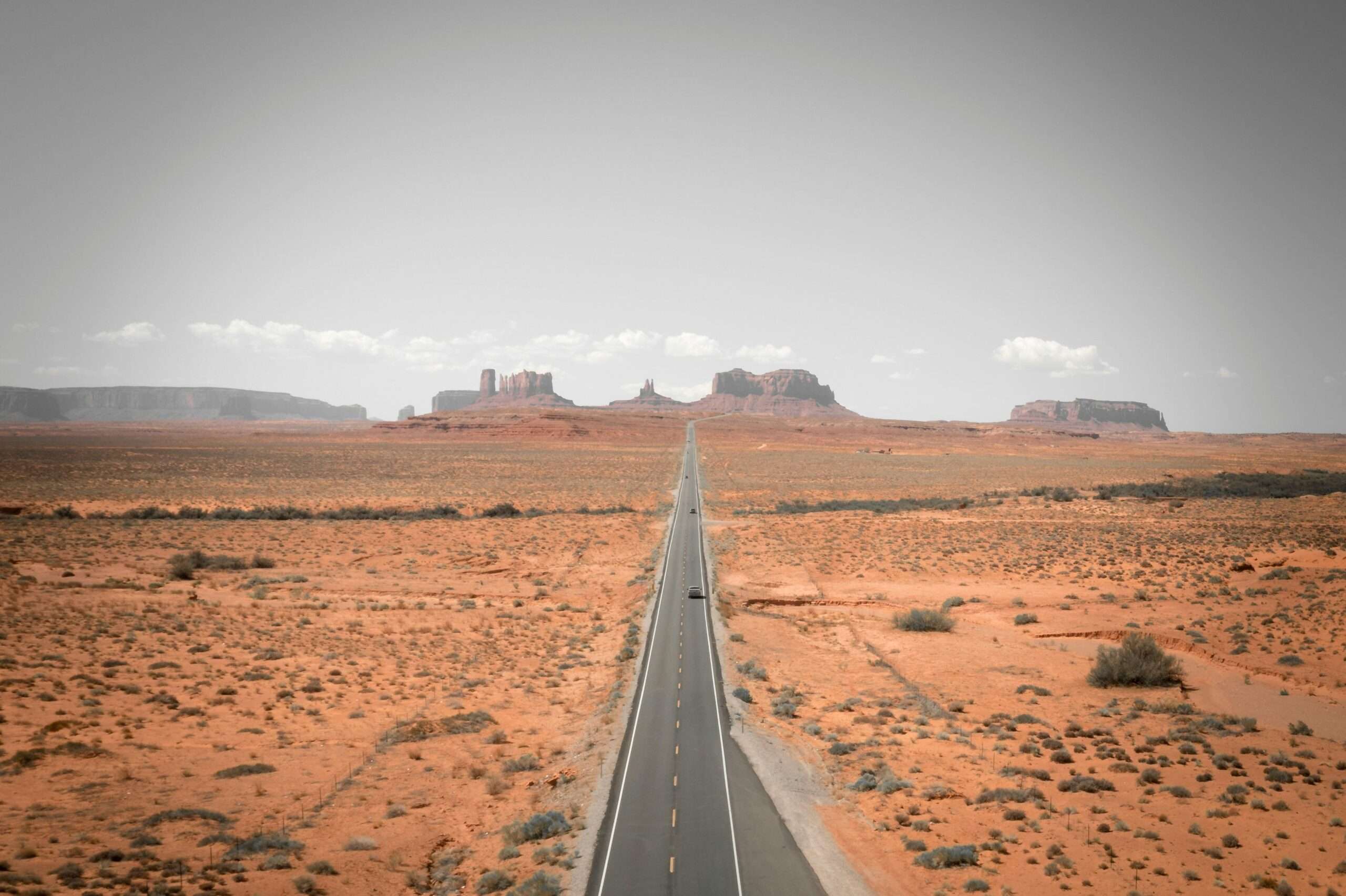 An Arizona highway juts to distant rock formations.