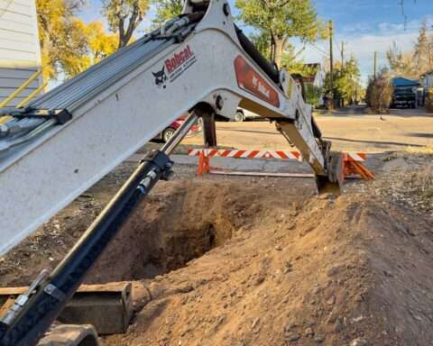 A construction vehicle lowers a digging arm for a gas line and redevelopment.