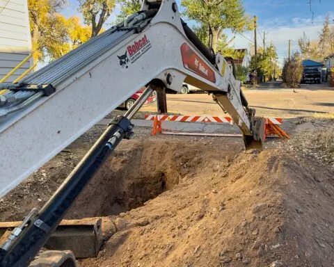 A construction vehicle lowers a digging arm for a gas line and redevelopment.