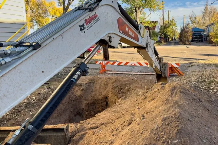 A construction vehicle lowers a digging arm for a gas line and redevelopment.