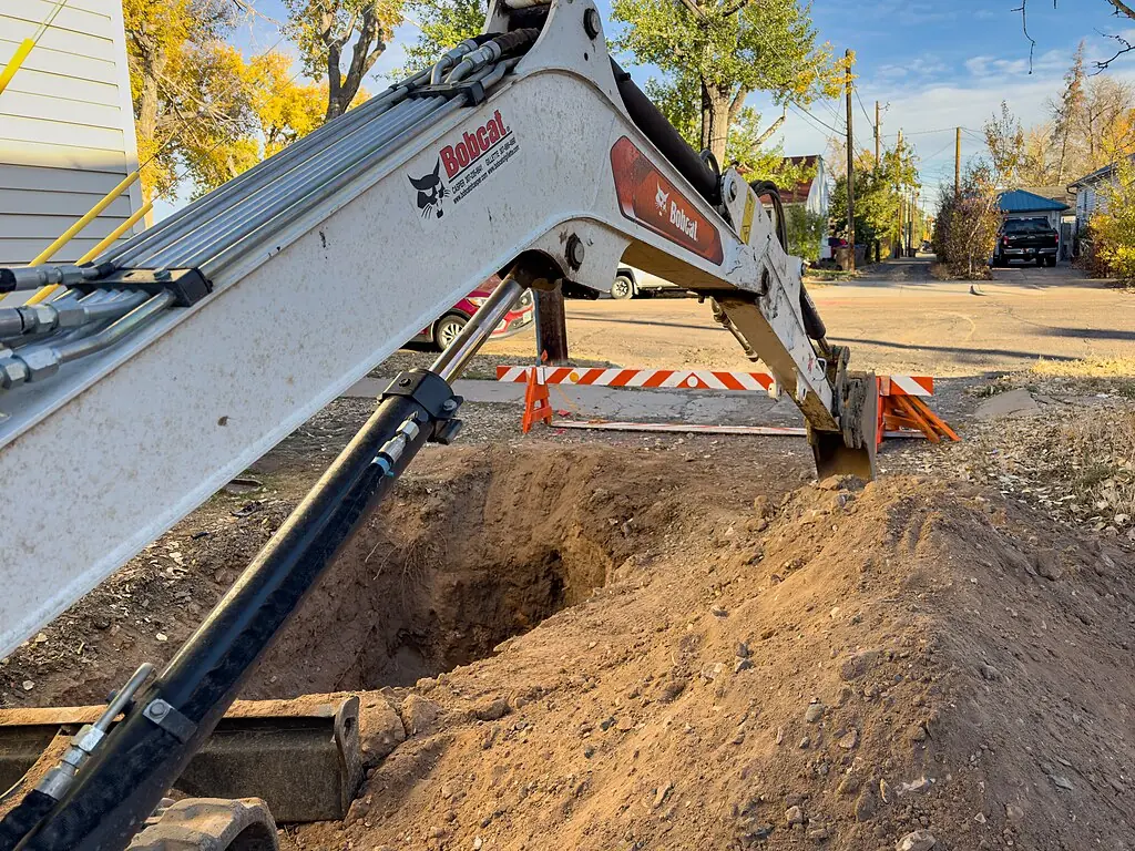 A construction vehicle lowers a digging arm for a gas line and redevelopment.