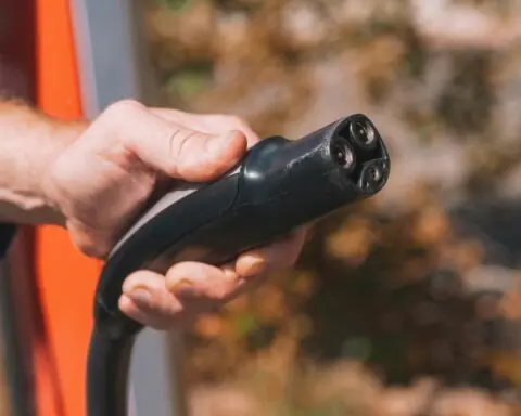 A hand holding a electric vehicle charging cable.