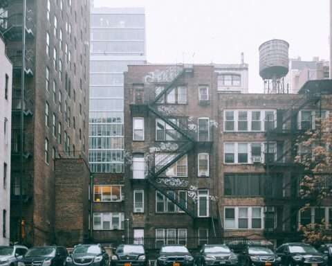 A housing complex in New York City from across a parking lot.