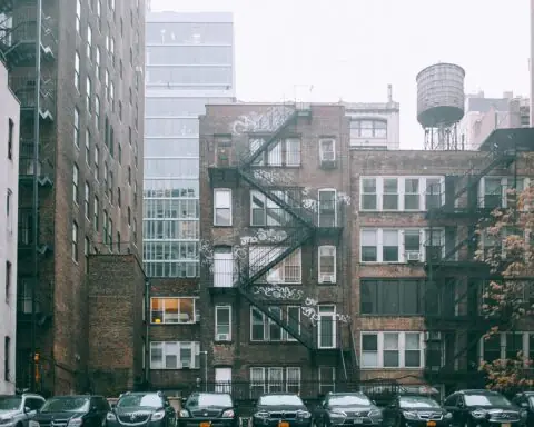 A housing complex in New York City from across a parking lot.