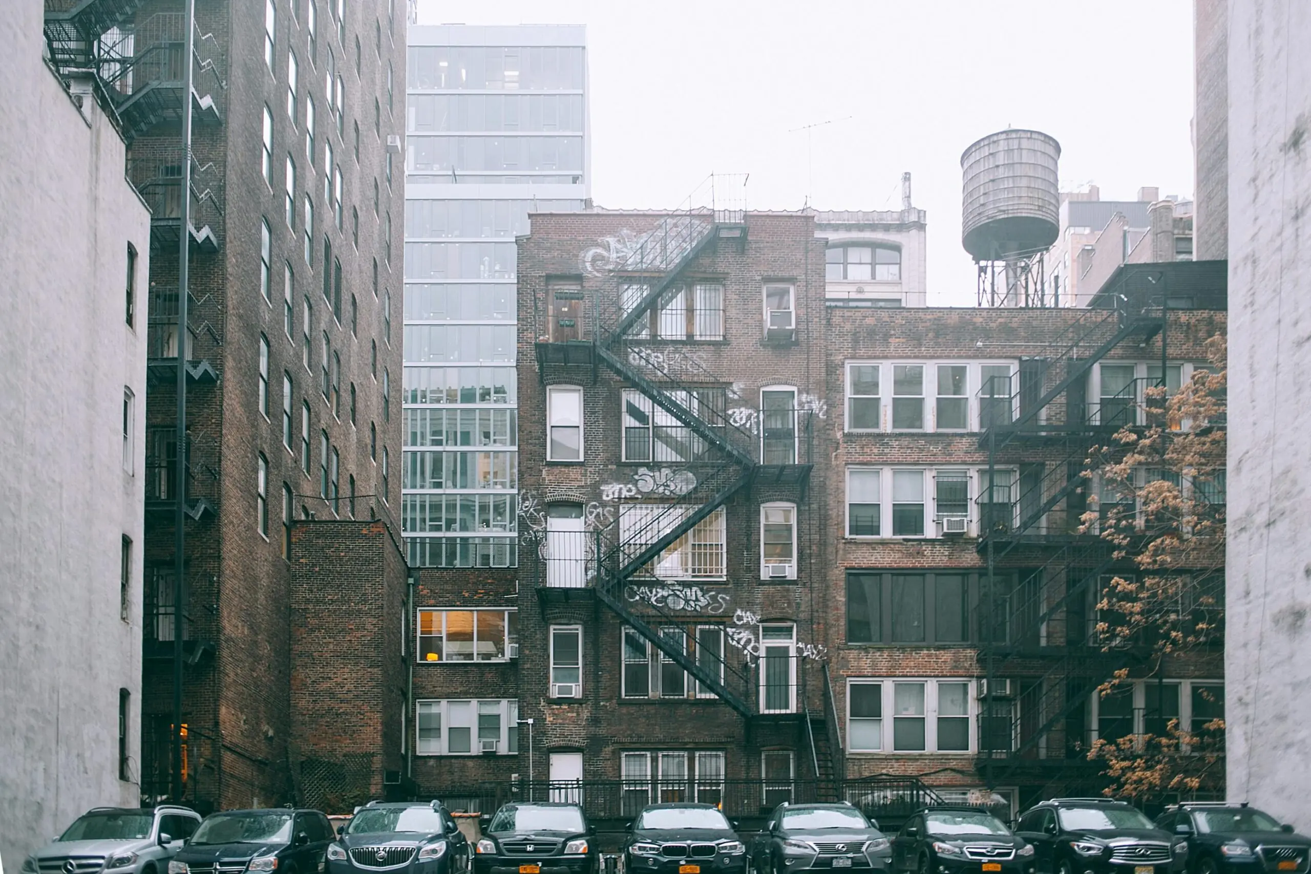 A housing complex in New York City from across a parking lot.