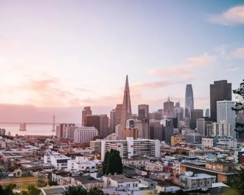 The San Francisco skyline before a blinding sun.
