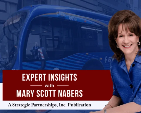 Mary Scott Nabers before an electric bus for her column about transit-oriented developments.