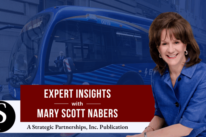 Mary Scott Nabers before an electric bus for her column about transit-oriented developments.