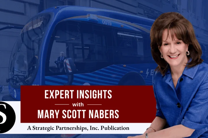 Mary Scott Nabers before an electric bus for her column about transit-oriented developments.