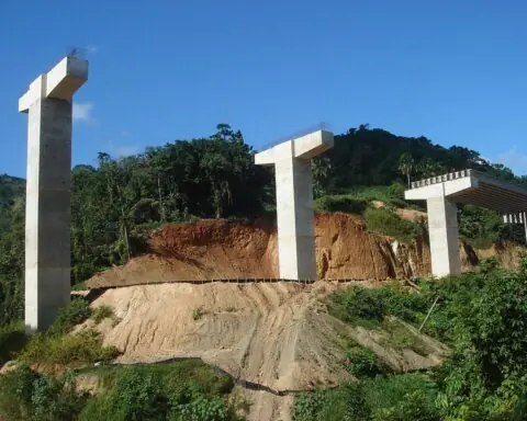 A highway construction project with concrete pillars for a bridge.