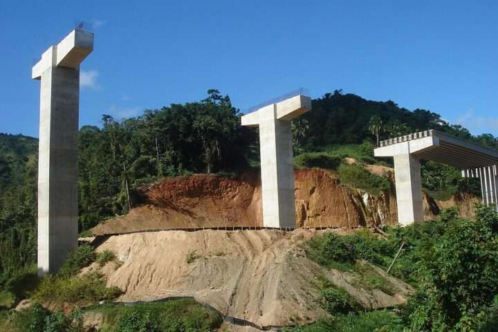 A highway construction project with concrete pillars for a bridge.