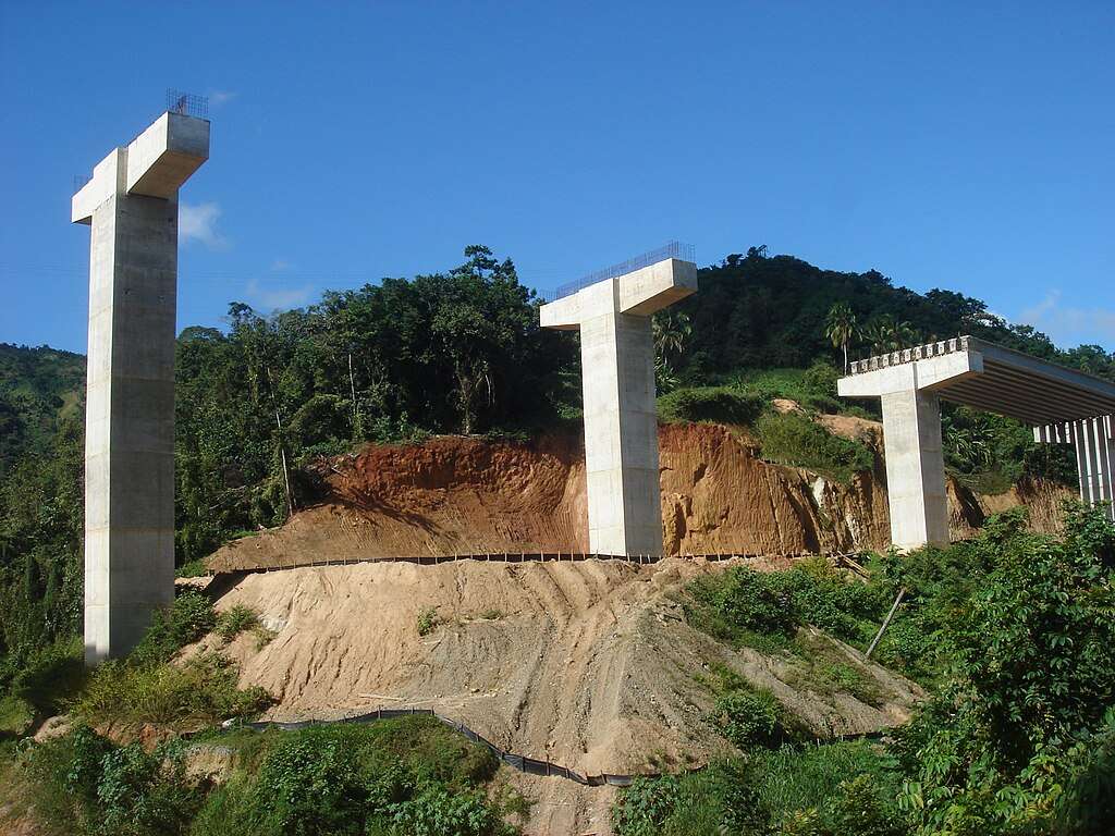 A highway construction project with concrete pillars for a bridge.