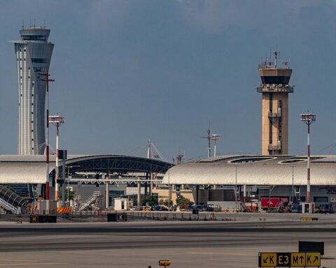 An air traffic control tower at an airport on a cloudy day.
