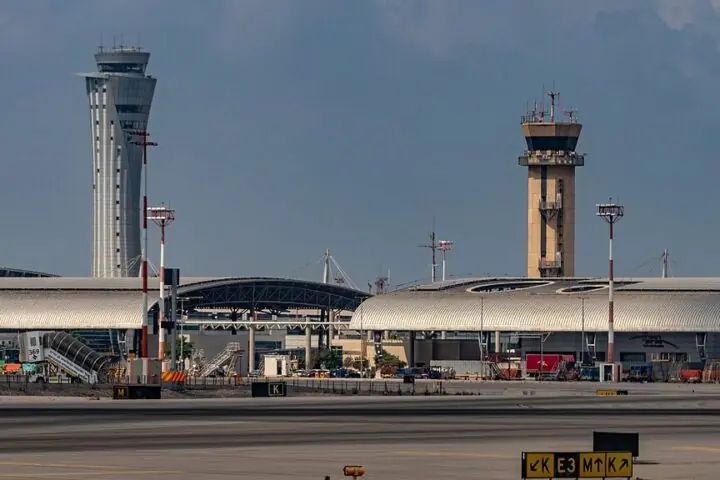 An air traffic control tower at an airport on a cloudy day.