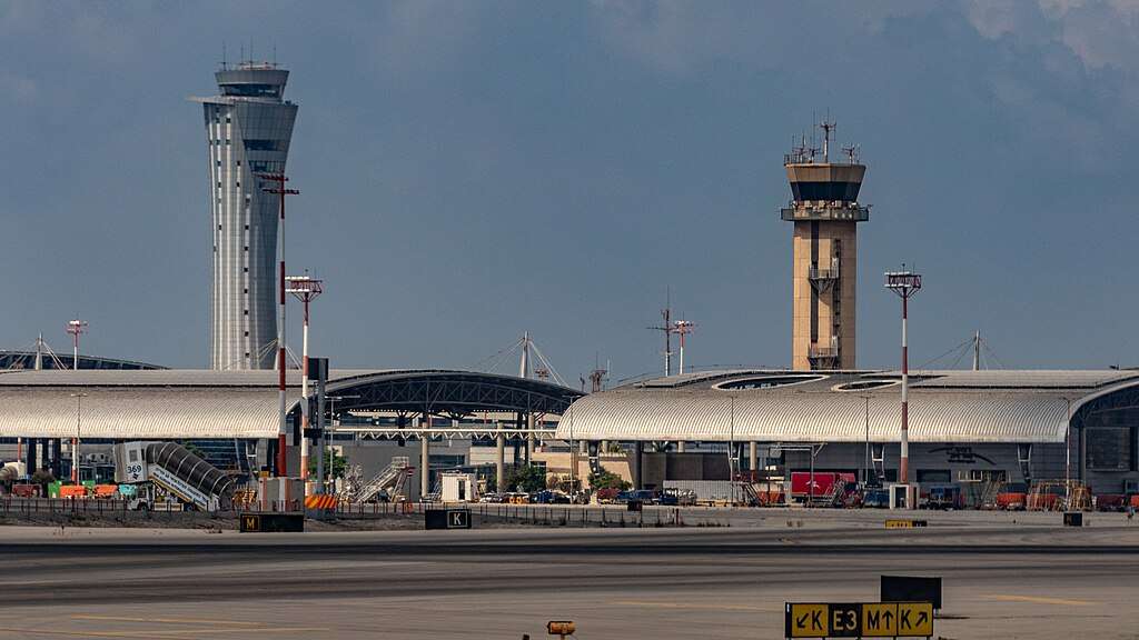 An air traffic control tower at an airport on a cloudy day.