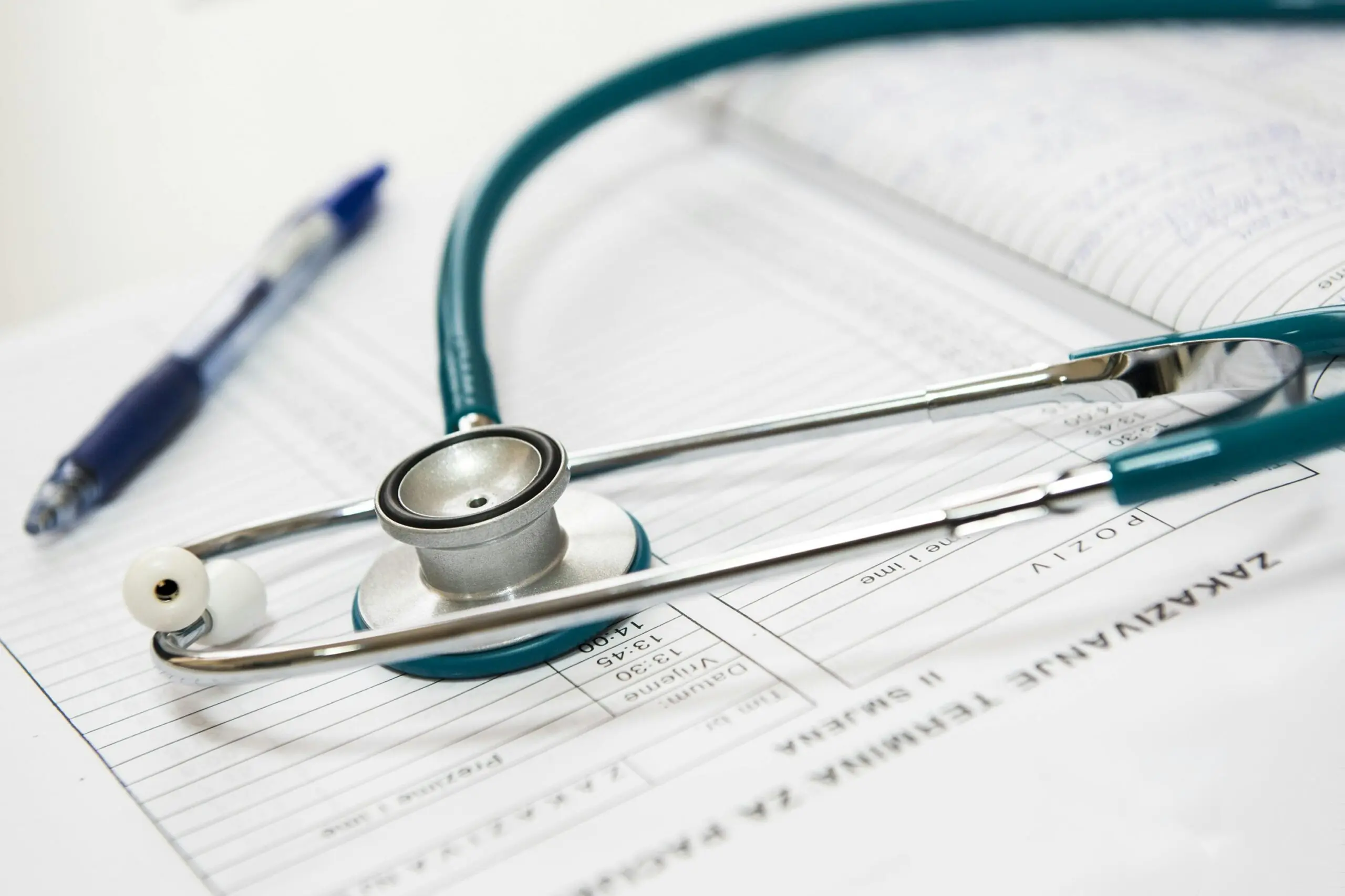 A stethoscope and a pen on a paper.