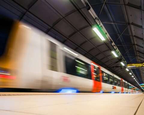 A train passes by a platform in a train station.