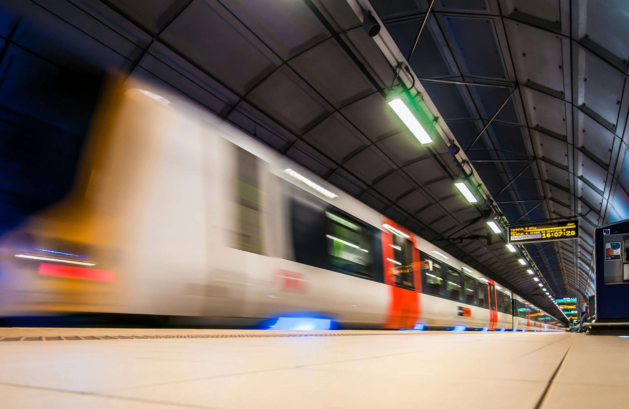 A train passes by a platform in a train station.