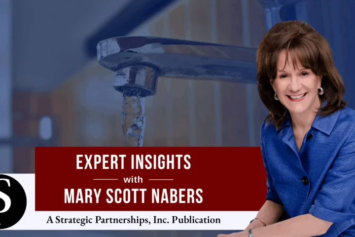 Mary Scott Nabers before a pouring faucet with water dripping out.