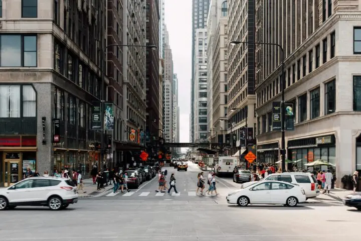 A city street in Chicago funded partially by state funding with people and cars.