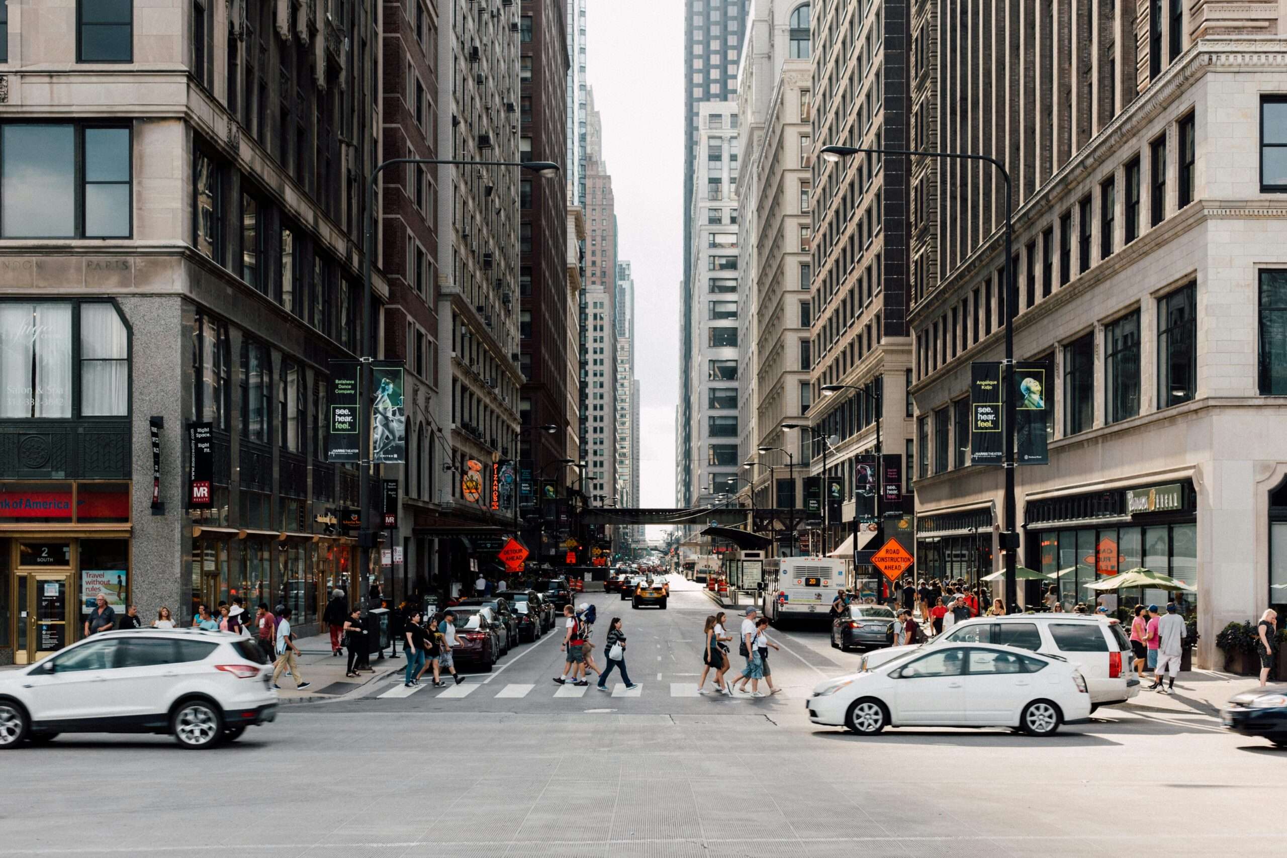A city street in Chicago funded partially by state funding with people and cars.