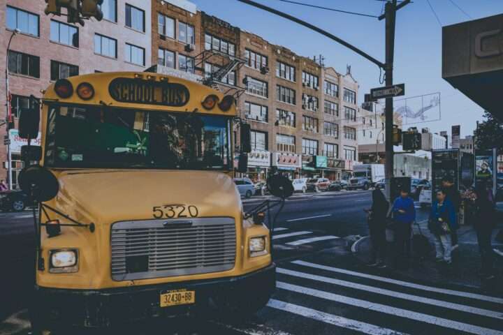 A yellow school bus along a busy street in New York City.