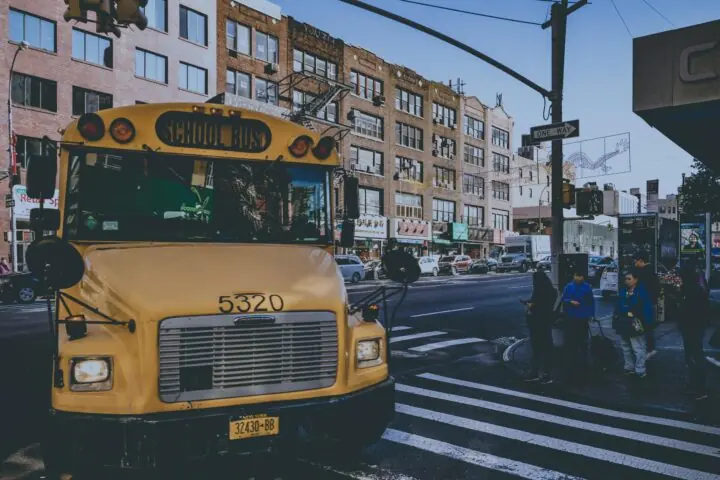 A yellow school bus along a busy street in New York City.