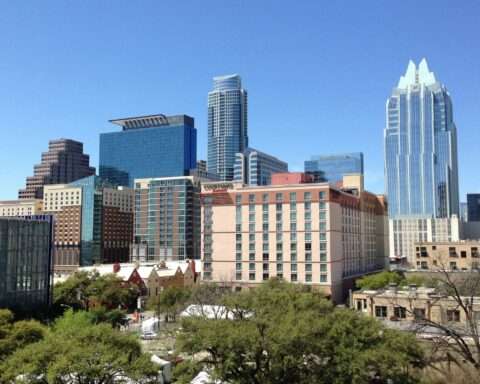 The Austin city skyline before a blue sky.