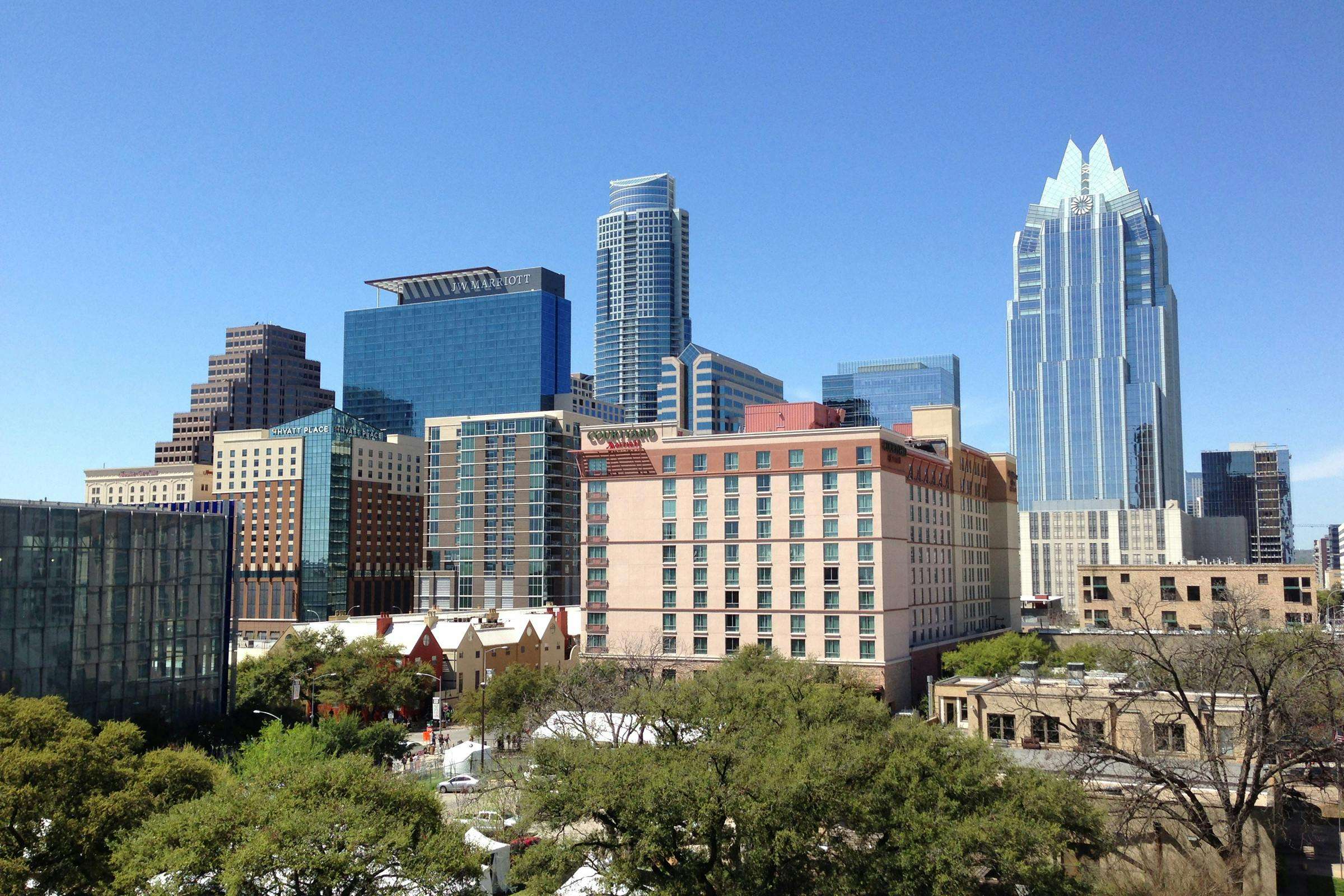 The Austin city skyline before a blue sky.
