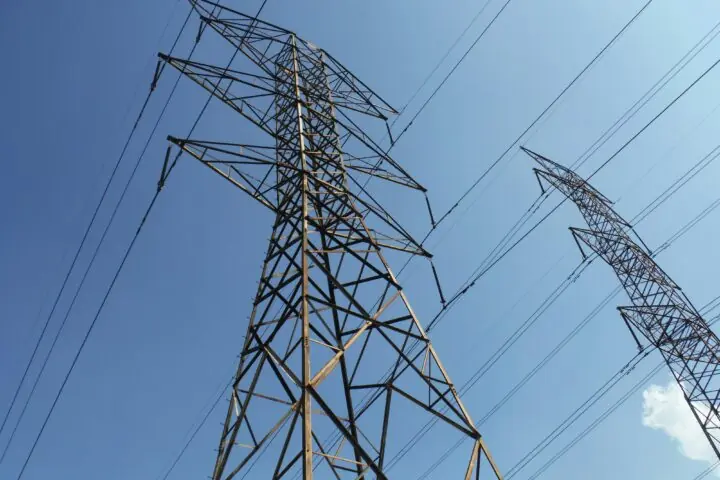 Two energy transmission towers before a blue sky.