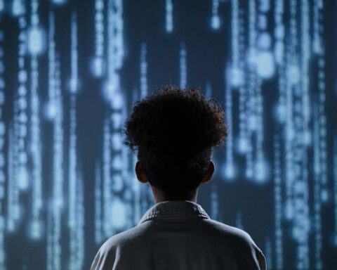 The behind of a person looking at digitized code along a wall.