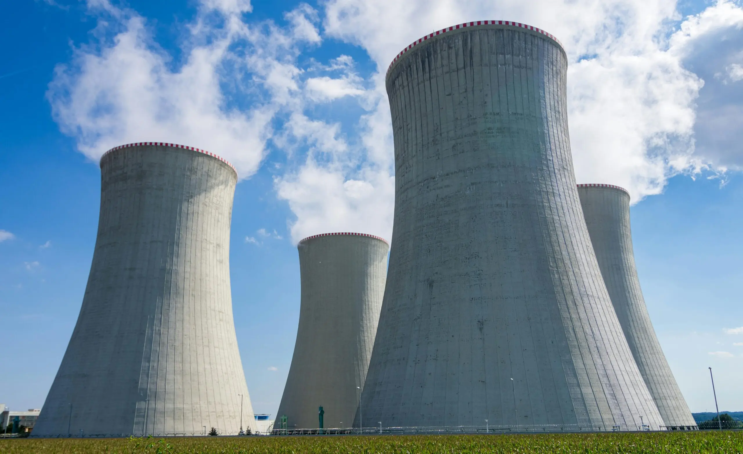 Silos as part of a nuclear reactor before a blue sky.