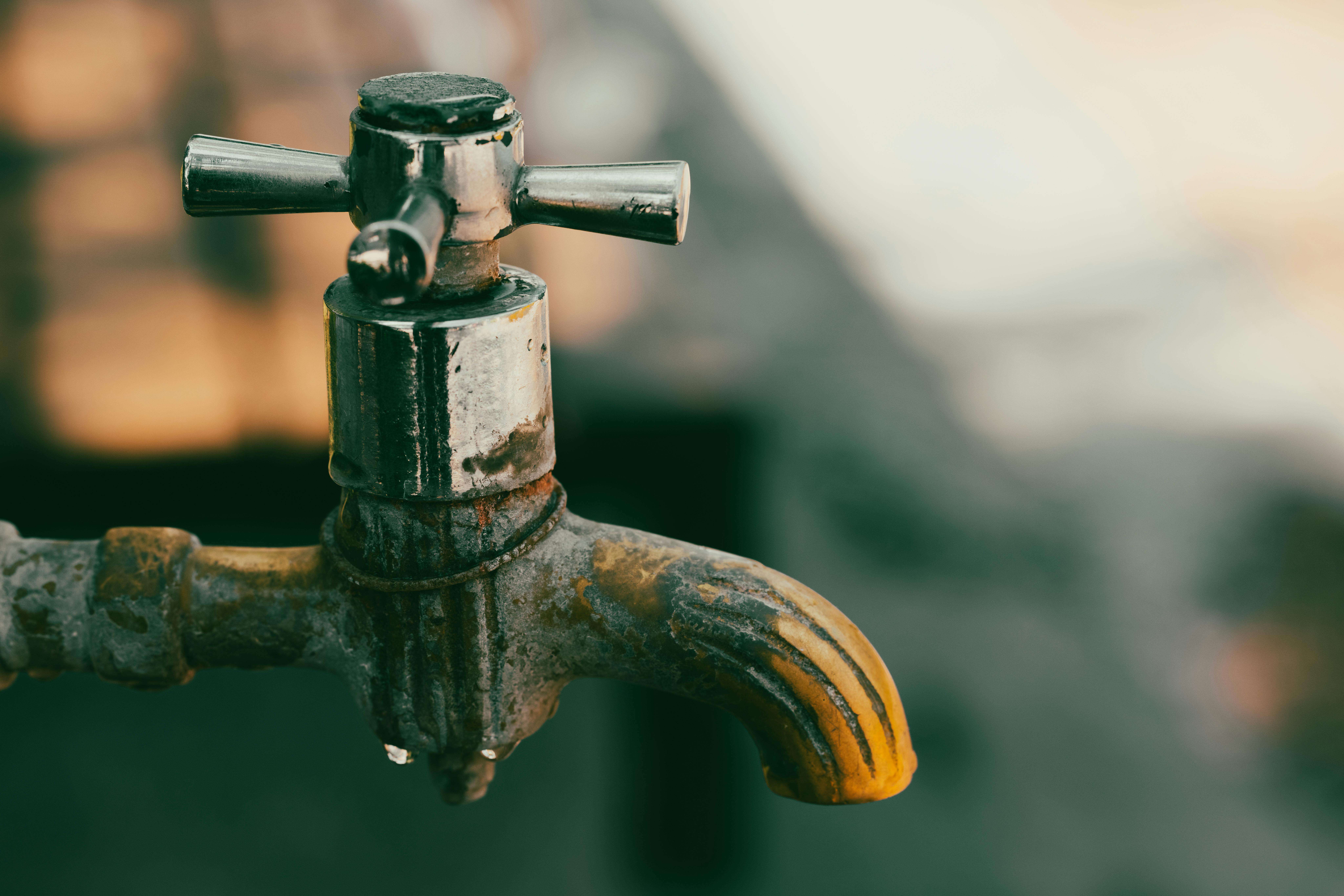 A metal pipe closed before a blurred background.